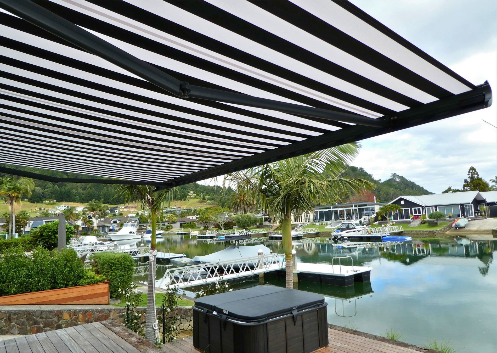 Striped Fetuna cassette awning over a waterfront deck